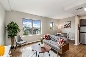 a living room with a couch and a table in front of a window